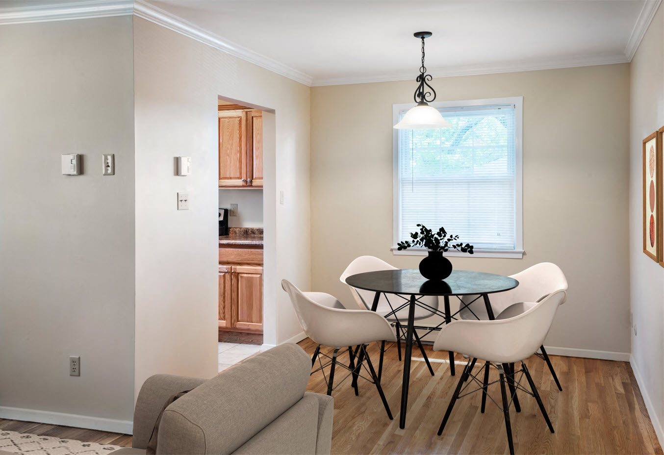 A dining room with a glass table and white chairs.