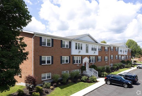 A row of townhouses with a car parked in front.