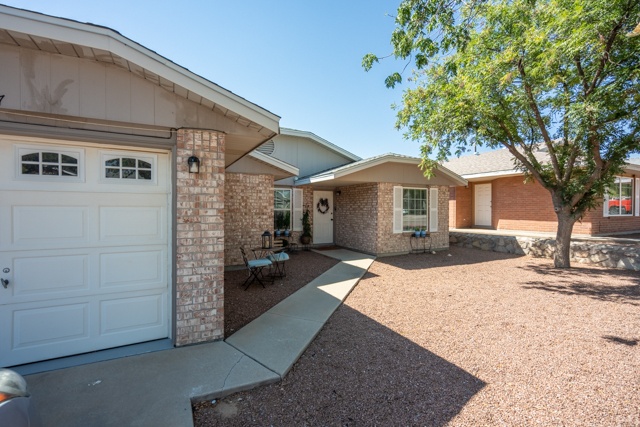 A house with a white garage door is surrounded by a gravel driveway.