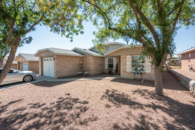 A house with a driveway and a tree in front.