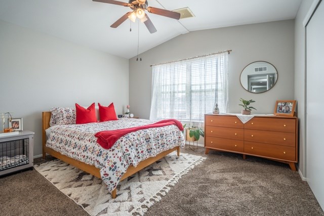 A bedroom with a bed, dresser, and ceiling fan.