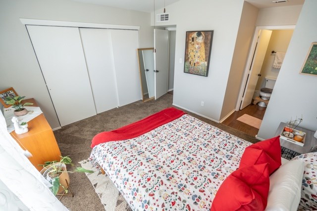 A bedroom with a bed, a dresser, and a mirror.