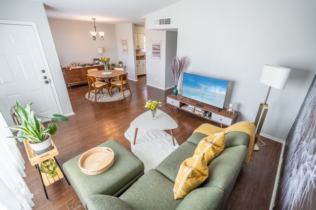A living room with a green couch and a white coffee table.