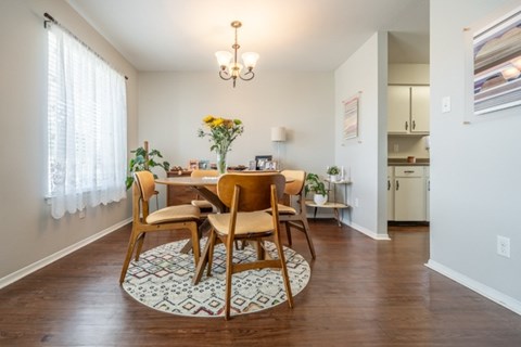 A dining room with a round table and chairs.