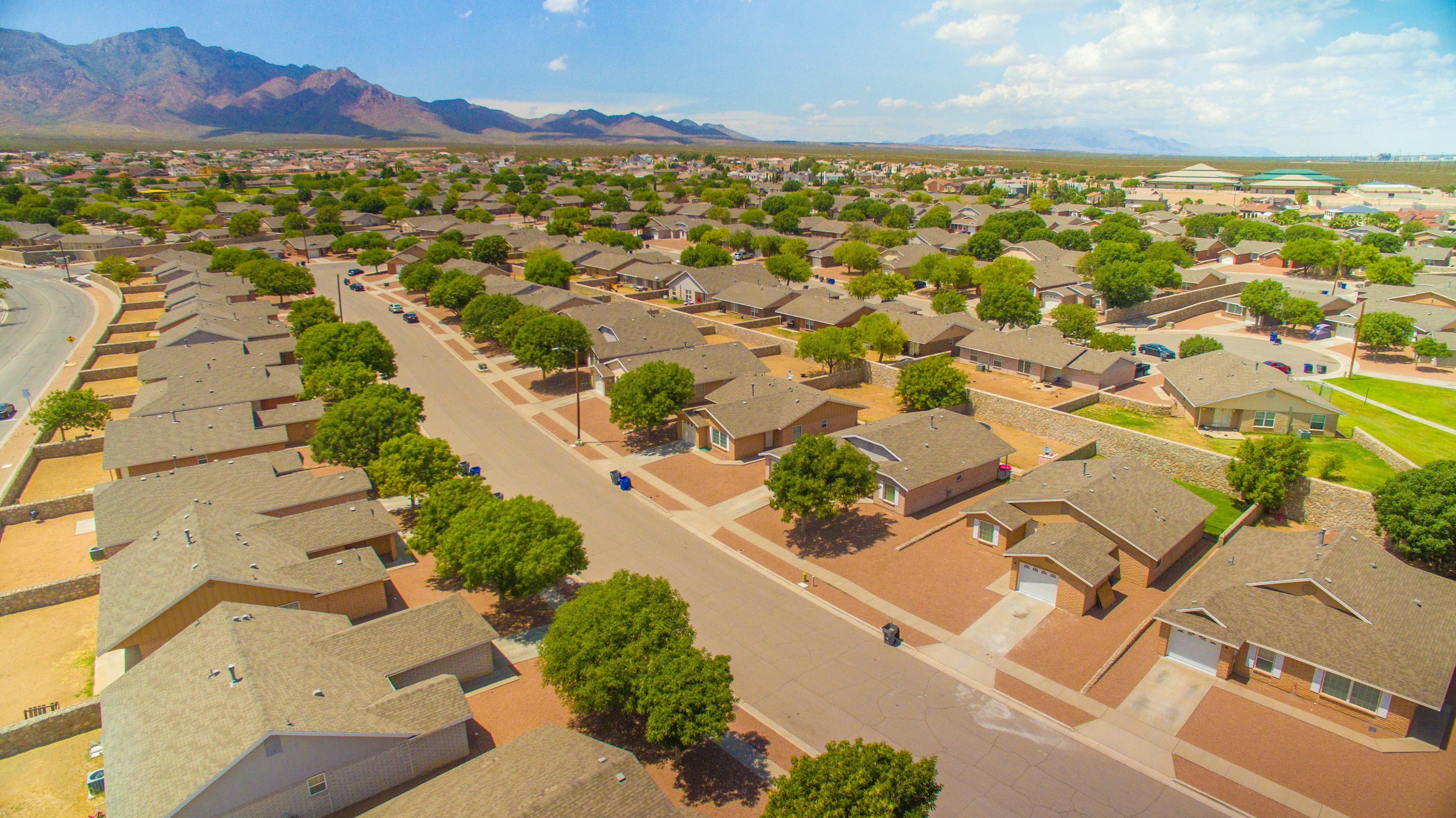 an aerial view of the neighborhood of houses with mountains in the background at Community splash park at the Village at Cottonwood Springs, El Paso TX