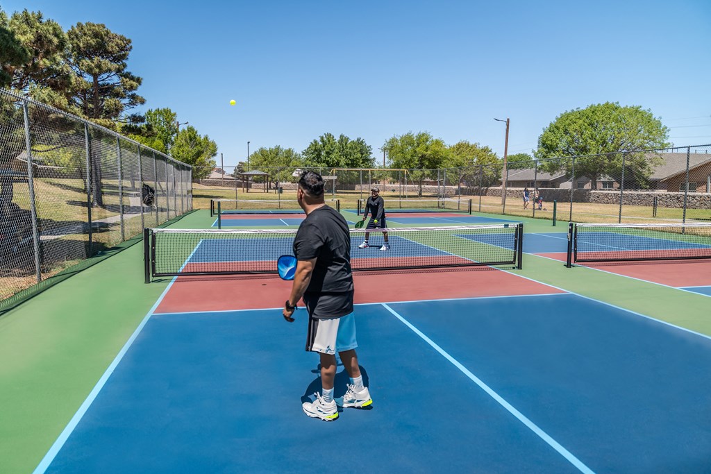 people playing tennis on a tennis court  at The Village at Cottonwood Springs, Texas