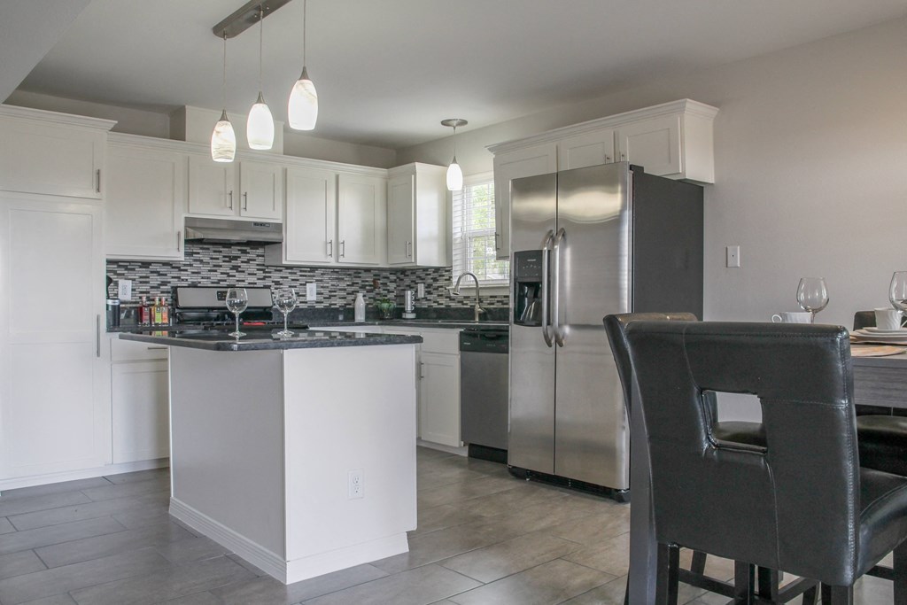 a kitchen with white cabinets and stainless steel appliances at Village of Cottonwood Springs, El Paso TX