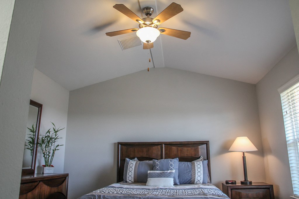 a bedroom with a ceiling fan and window at Village of Cottonwood Springs in El Paso