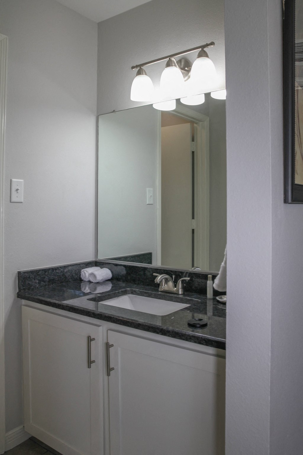 a bathroom with a sink and a mirror at The Village at Cottonwood Springs, El Paso, 79934