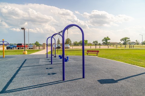 A blue swing set and parking lot.