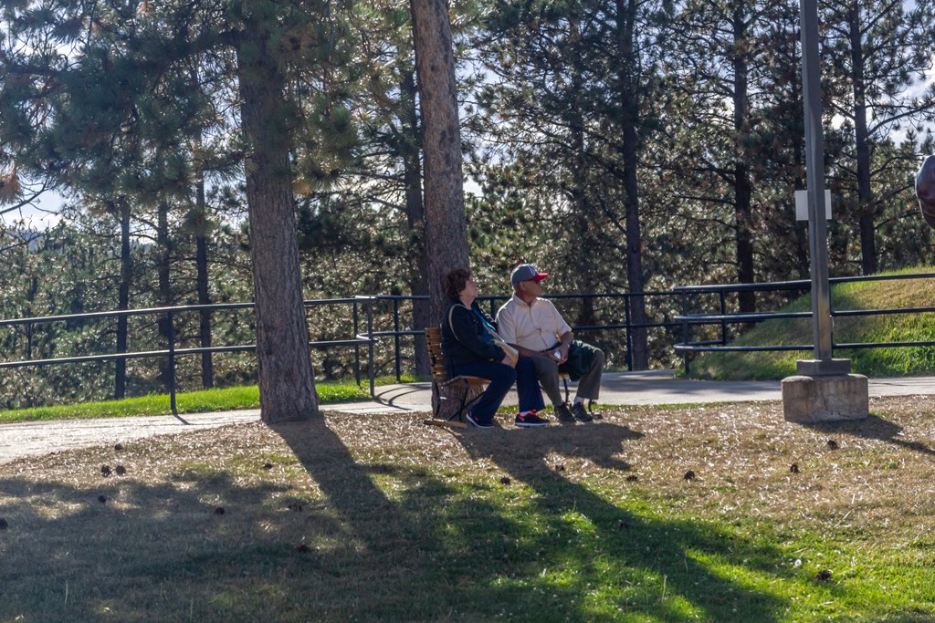 two people sitting on a bench in a park  at Antelope Ridge, Box Elder, 57719