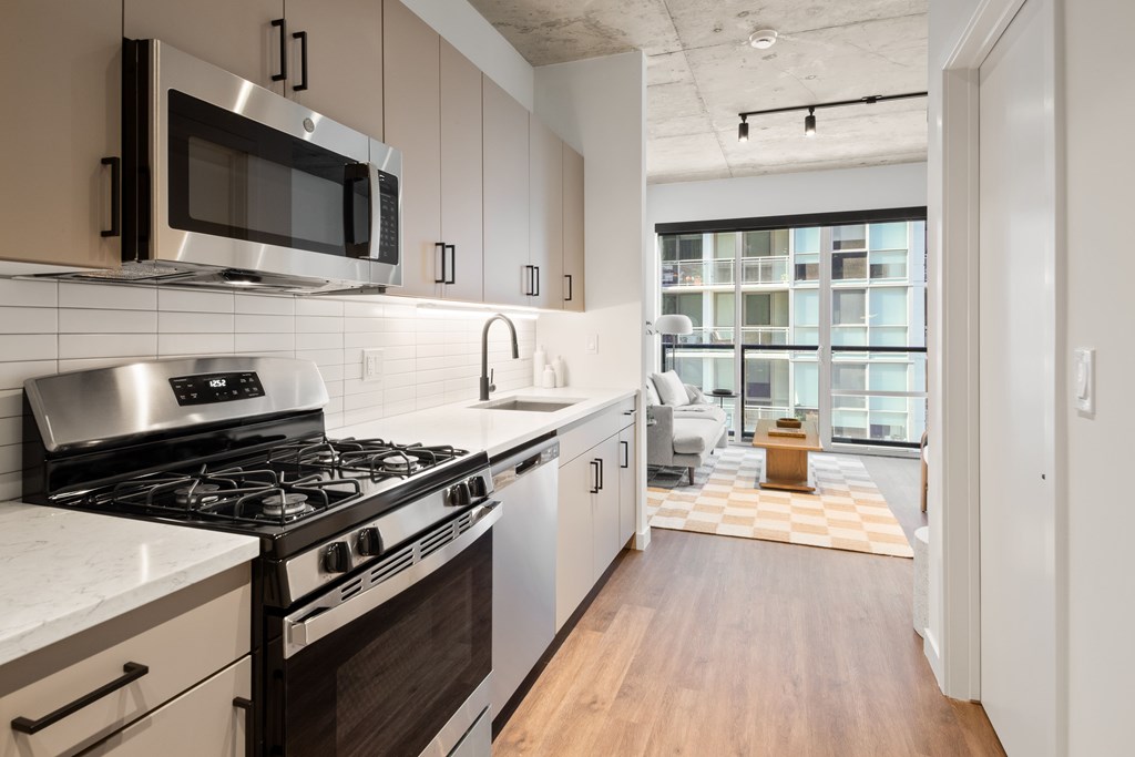A modern kitchen with a stove top oven and microwave above it.