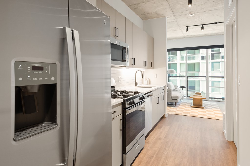 A modern kitchen with a refrigerator, stove, and microwave.