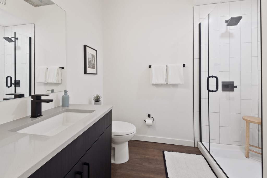 A bathroom with a white sink and a white toilet.