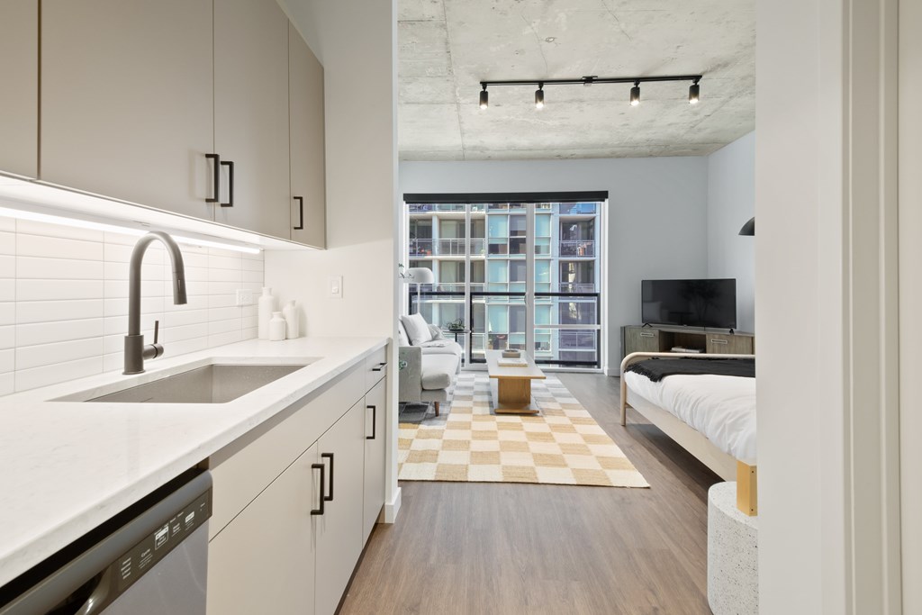 A modern kitchen with a checkered rug in the middle of the room.