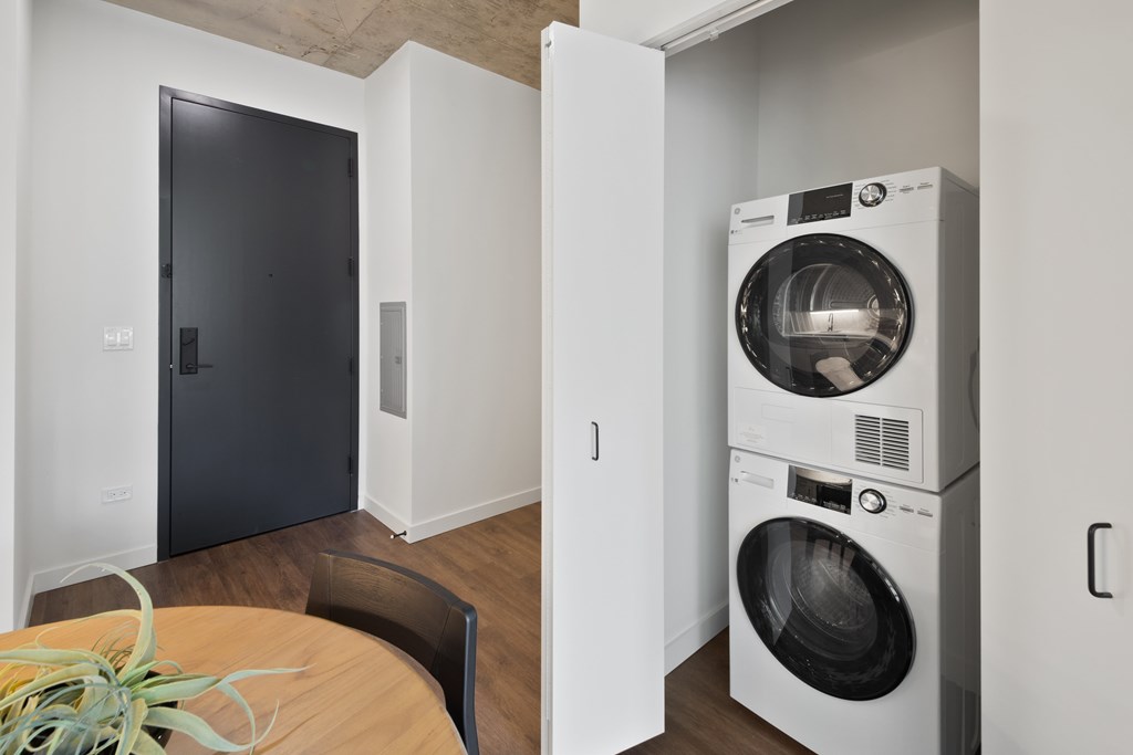 A modern laundry room with a washer and dryer stacked on top of each other.