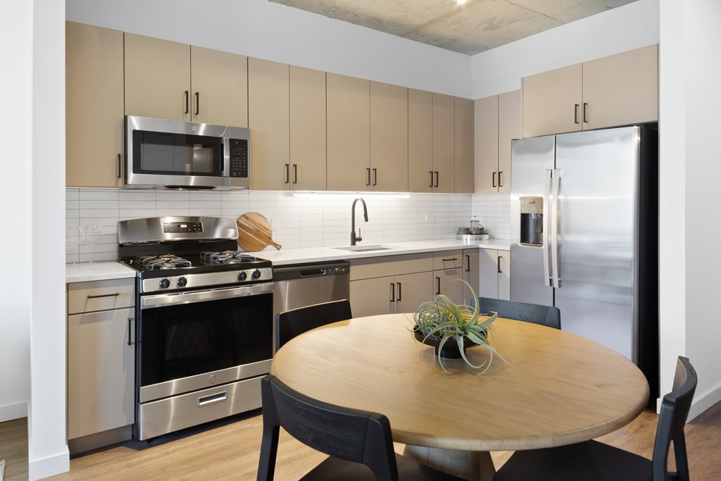 A kitchen with a wooden table and chairs.