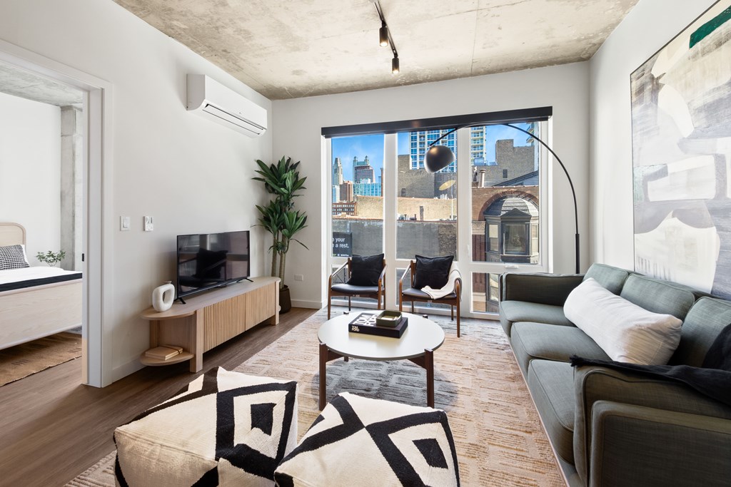 A living room with a large window overlooking a cityscape.