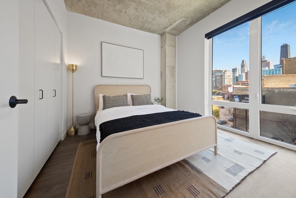 A bedroom with a large bed and a view of the city.