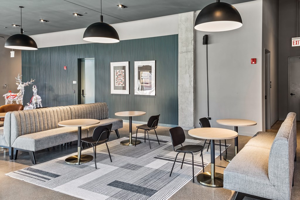 A modern waiting room with grey sofas and tables.