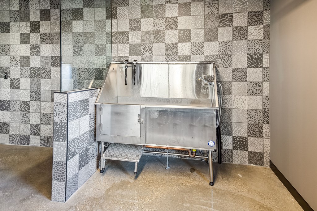 A bathroom with a checkered tile wall and a sink.