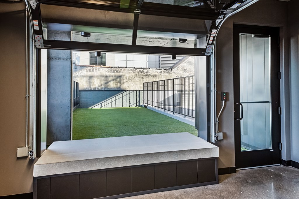 A view of a green field from a train station.