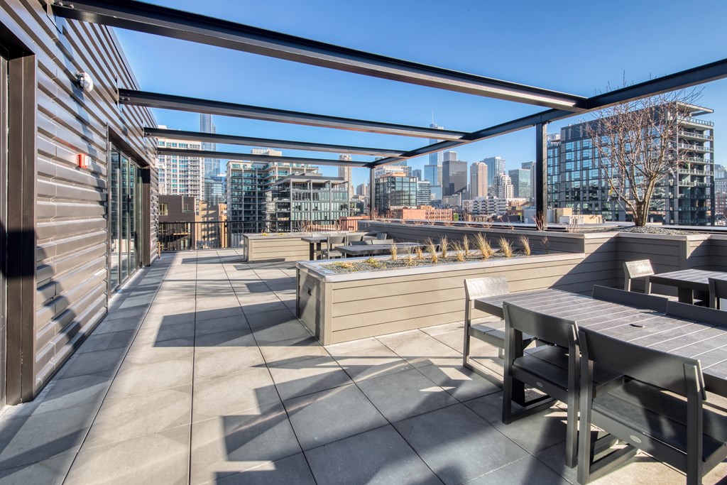 A patio with a table and chairs overlooking a city skyline.