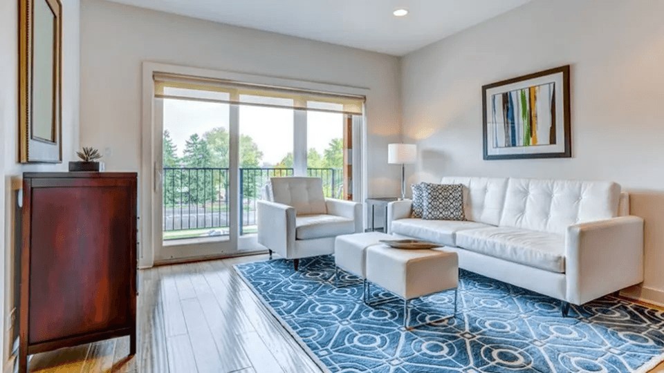 A living room with a white couch, a chair, and a small table.