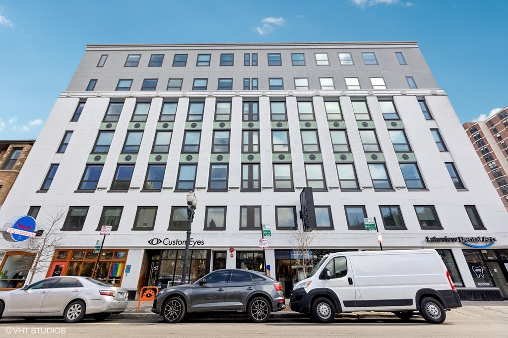 A white building with a Custom Eyes store on the ground floor.