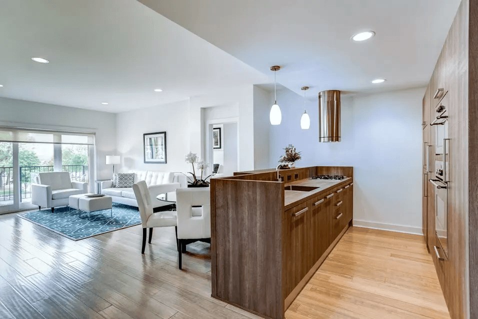 A modern kitchen with wooden cabinets and a dining table with chairs.