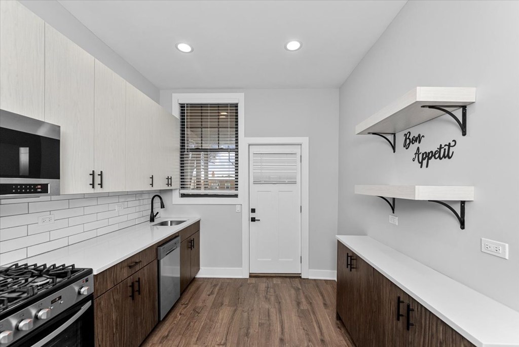 A modern kitchen with a white countertop and wooden cabinets.