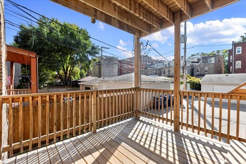 A wooden deck with a roof and a view of the street.