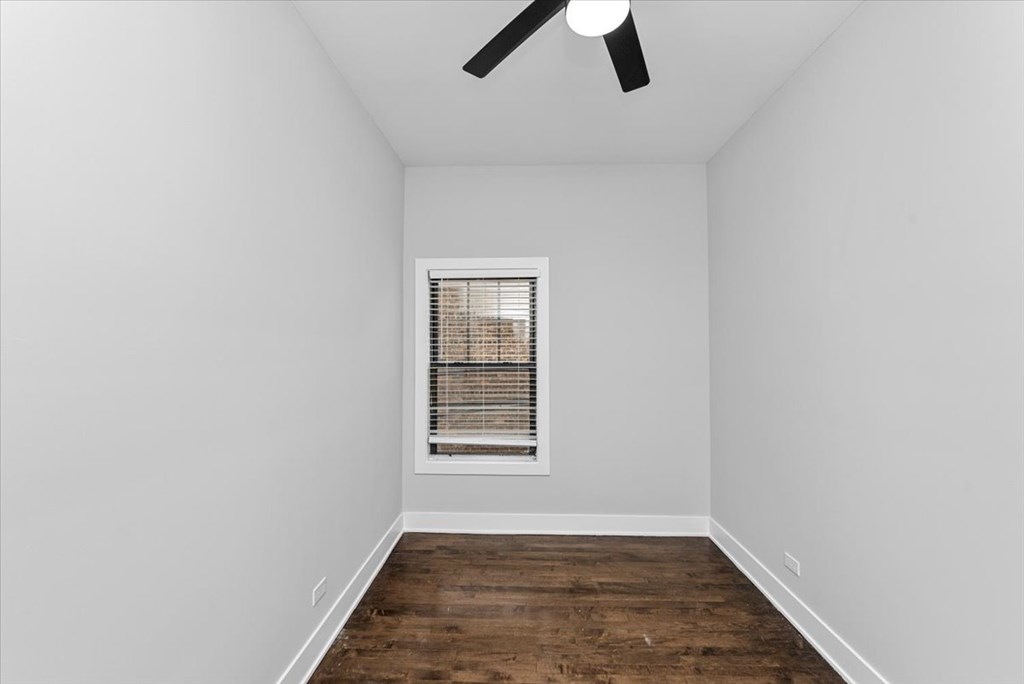 A room with a window and a ceiling fan.