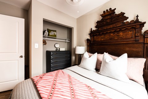 A bedroom with a large bed and a wooden headboard.