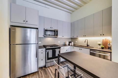 a kitchen with stainless steel appliances and a wooden table