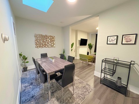 A dining room with a table and chairs.