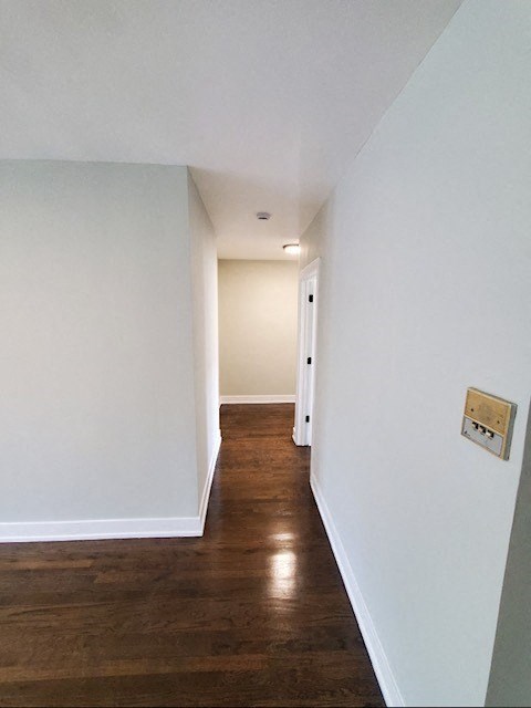a hallway with white walls and a wood floor