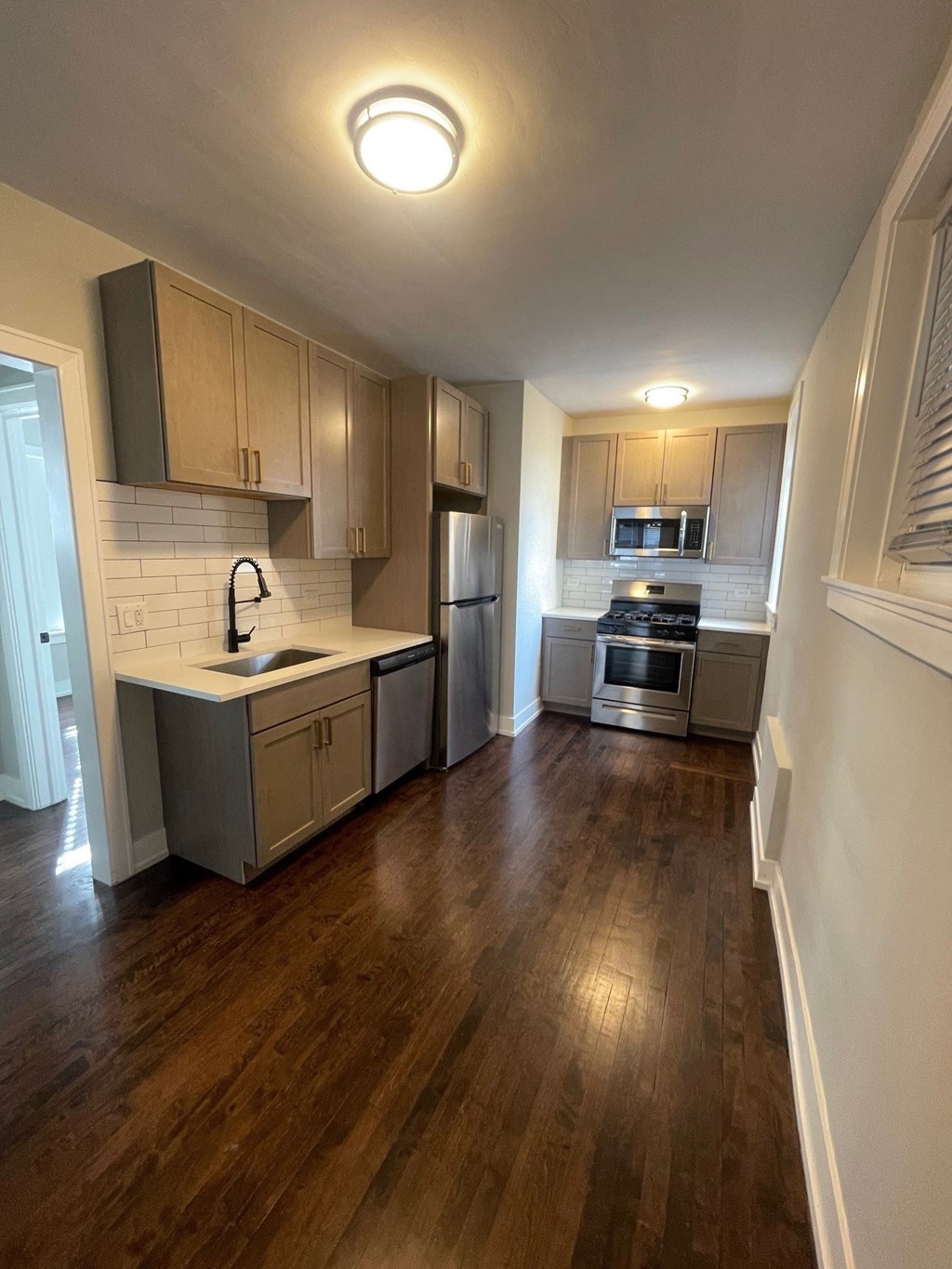 a kitchen with wooden floors and stainless steel appliances
