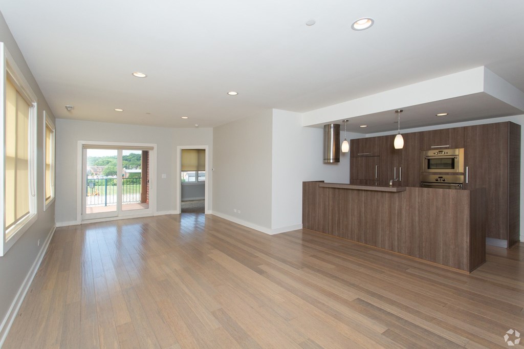A spacious room with wooden floors and a reception desk.