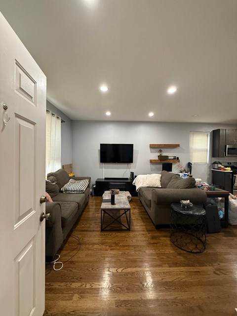 A living room with a grey couch and a black television.