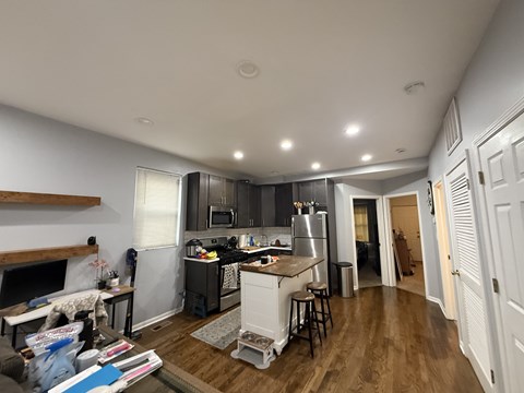A kitchen with a refrigerator, stove, and sink.