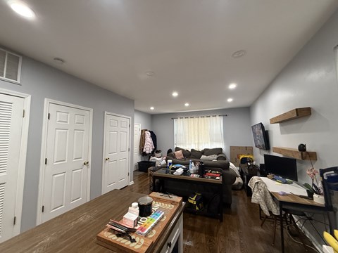 A room with a wooden floor and a white ceiling with lights.