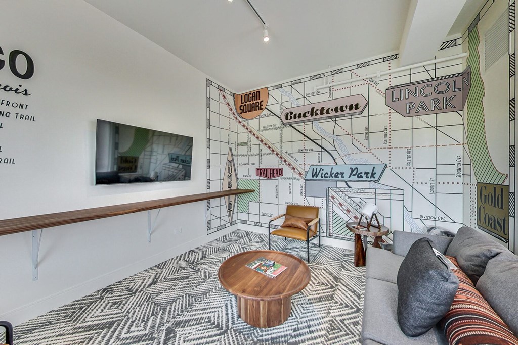 a living room with a large mural on the wall and a couch and chair in front of