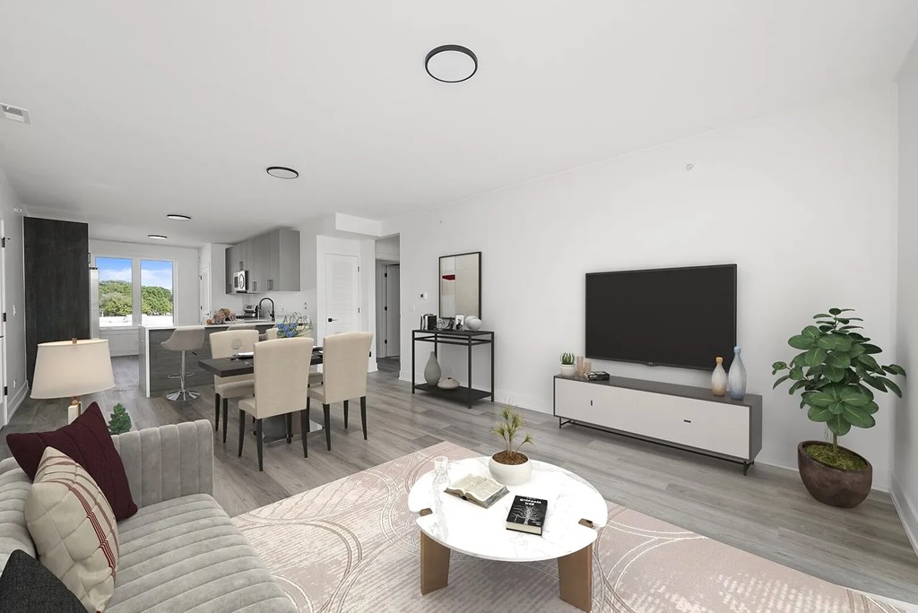 A modern living room with a white sofa, a coffee table, and a flat-screen TV.