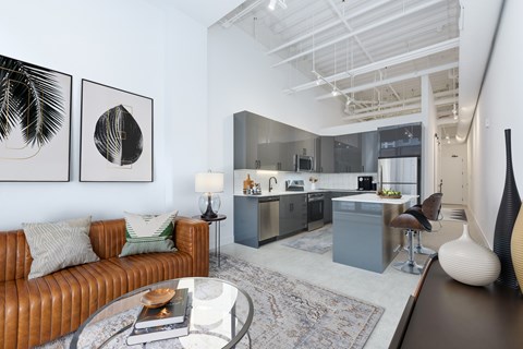 A modern living room with a brown leather couch and a glass coffee table.