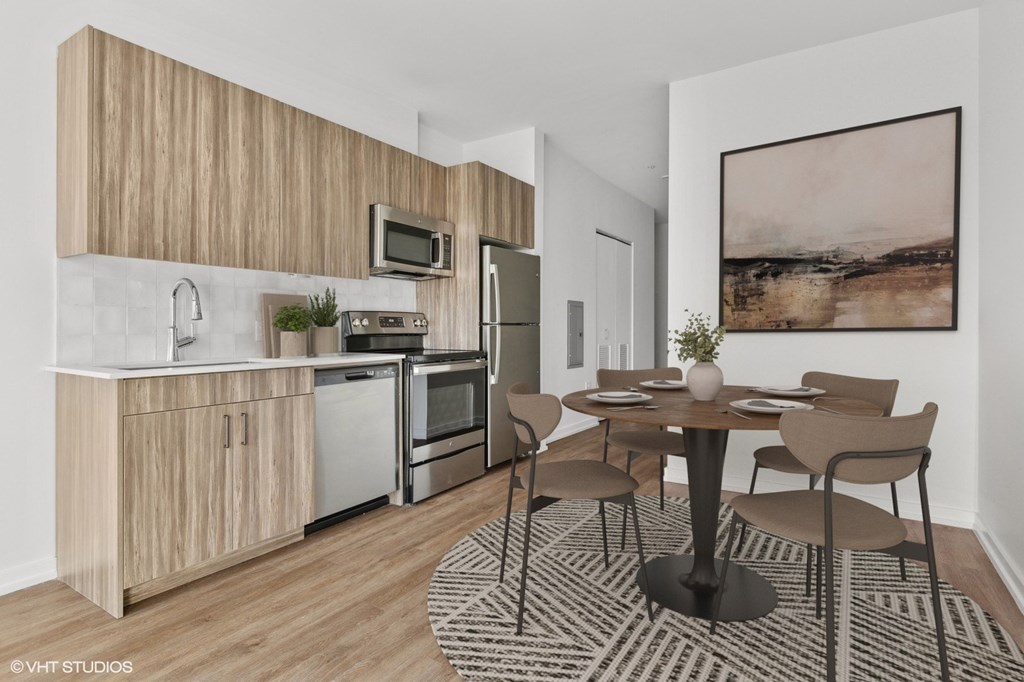 A modern kitchen with a dining table set for two.