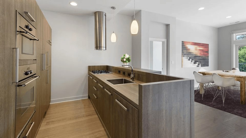 A modern kitchen with wooden cabinets and stainless steel appliances.