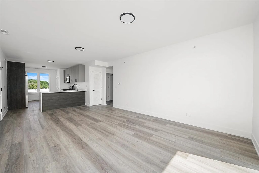 A spacious room with a grey floor and white walls.