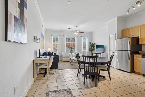 A kitchen with a dining table and chairs in the middle of the room.