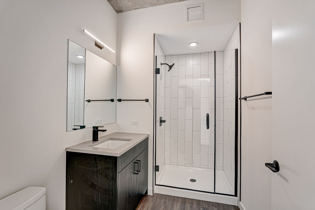 A modern bathroom with a walk-in shower and a sink.